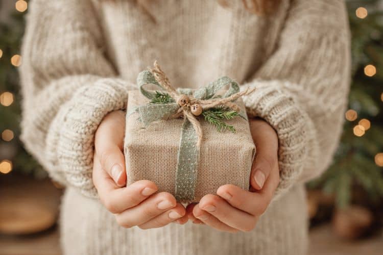 woman's hands holding a Christmas gift