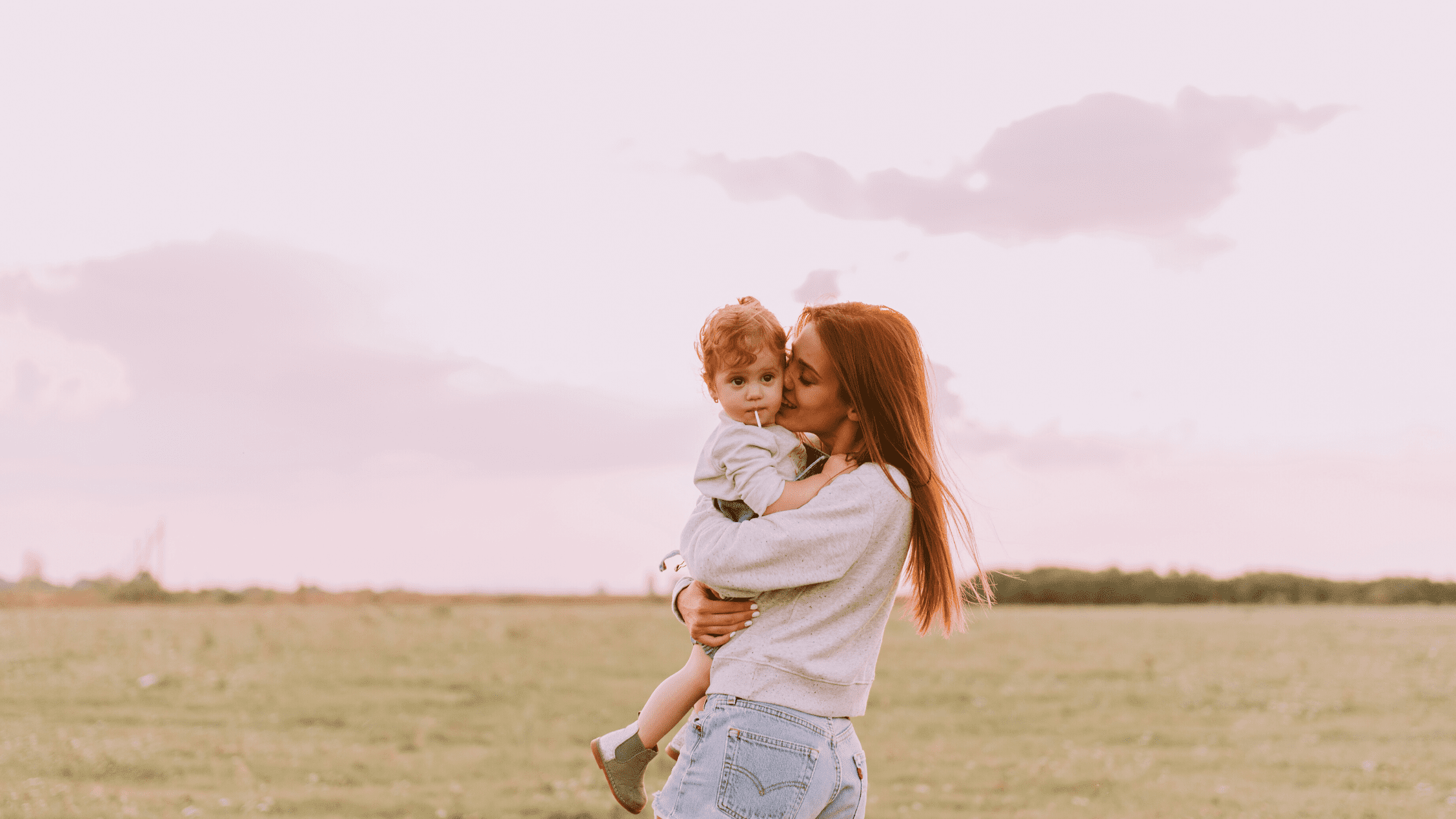 mother embracing a small child in a field