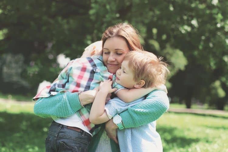 woman hugging her children
