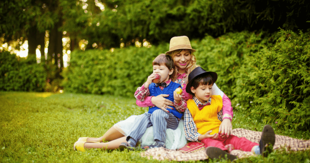 mother in a field with two boys wearing bright clothing and hats