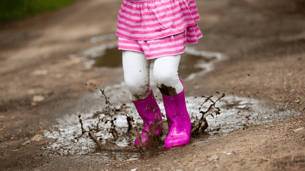 little girl splashing in a puddle