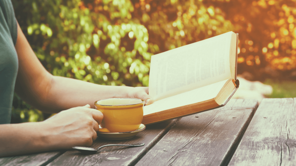 woman reading Bible and drinking coffee outdoors | Bible verses about hope in hard times