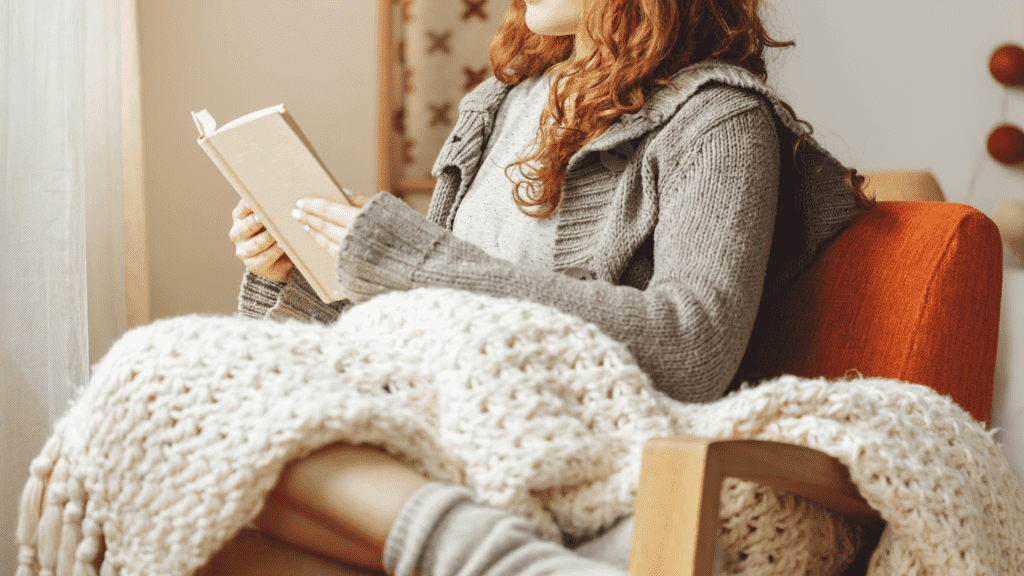 woman sitting in orange chair reading Bible | 10 Bible verses about hope in hard times