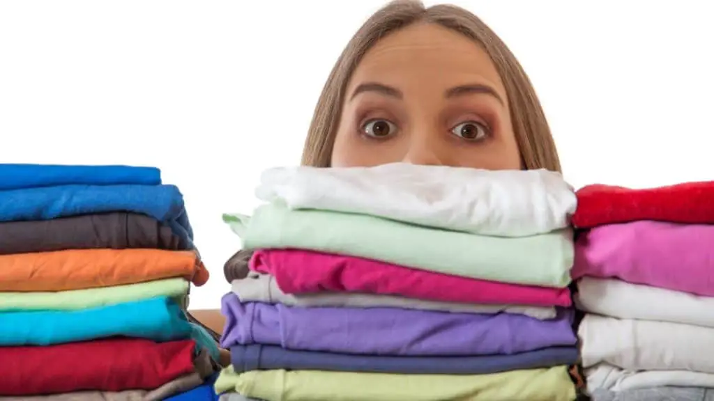 woman looking over piles of clothes on a shelf