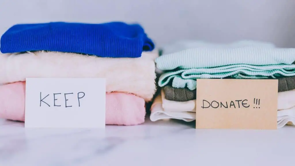 2 piles of shirts labeled "donate" and "keep"