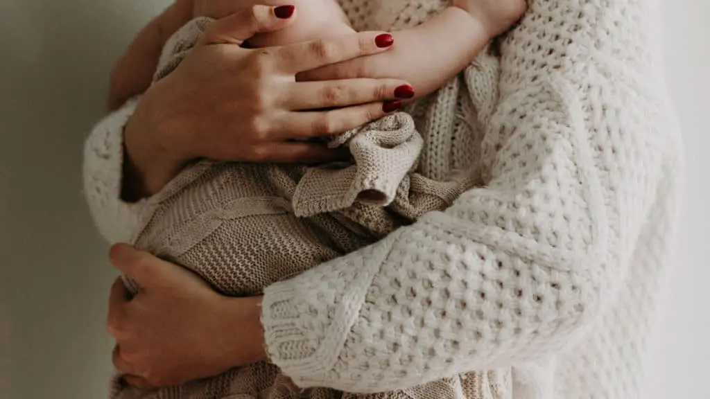 close up of woman's arms holding a small child