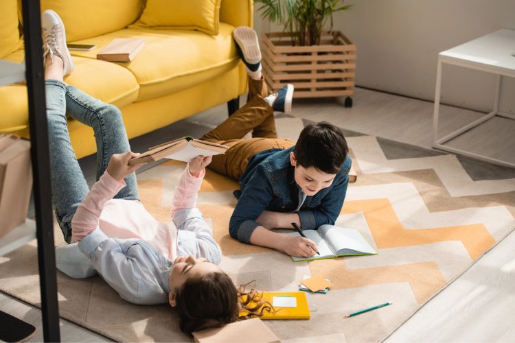 kids doing homeschool while laying on the floor