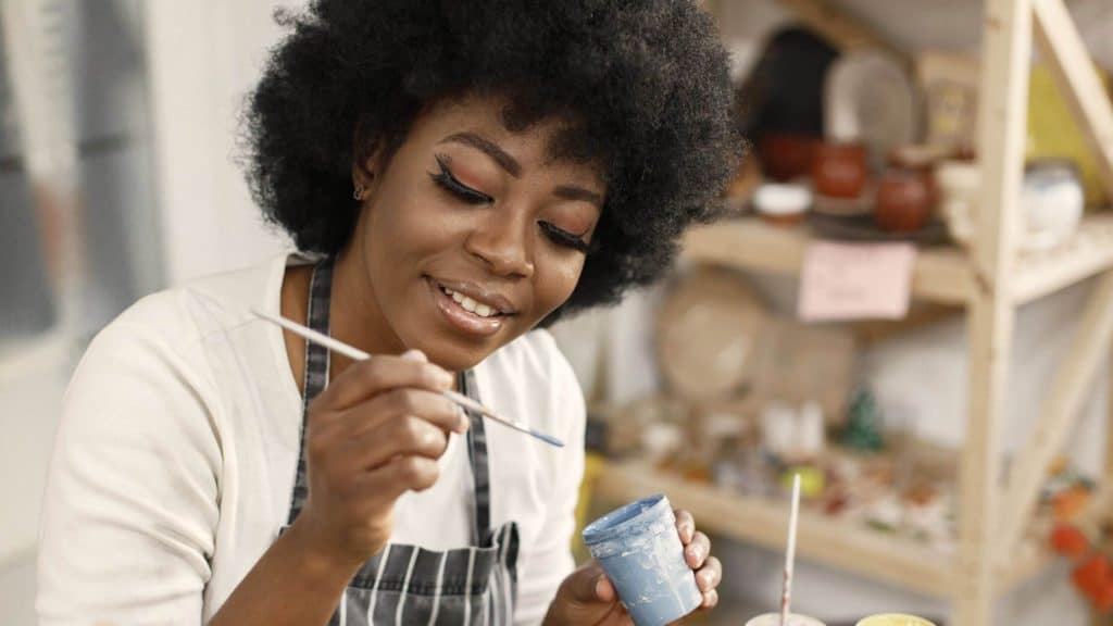 woman painting a piece of pottery