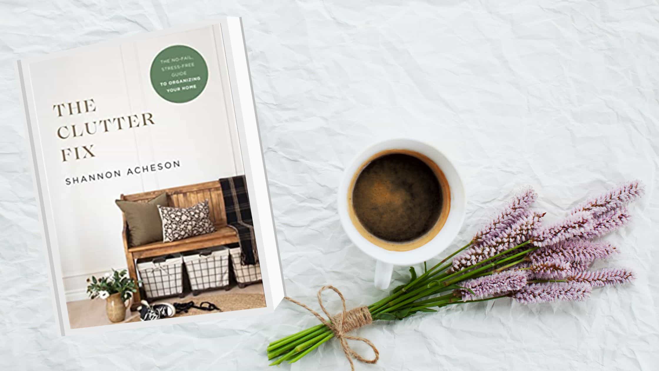 cover of The Clutter Fix displayed on a white background alongside a cup of coffee and purple flowers