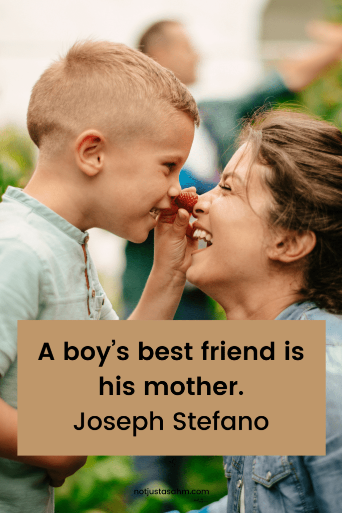 little boy touching his mother's nose with a strawberry