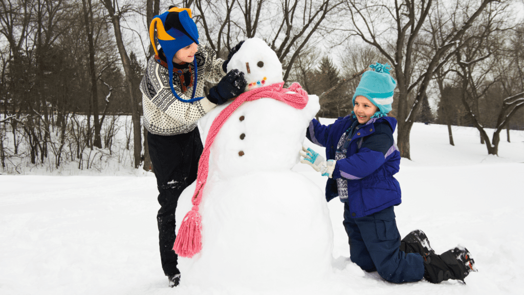 two children building a snowman