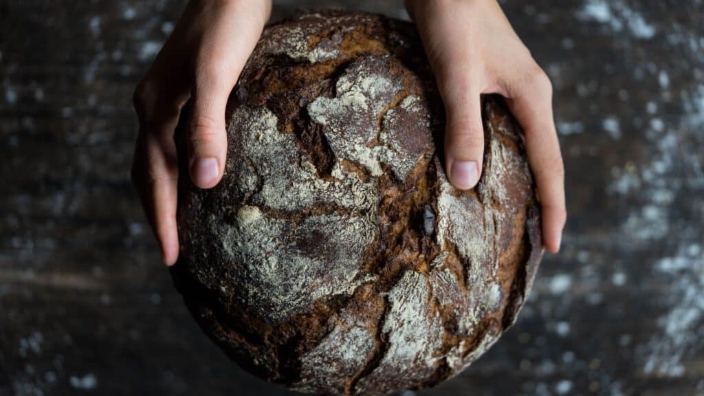 hands holding a loaf of bread