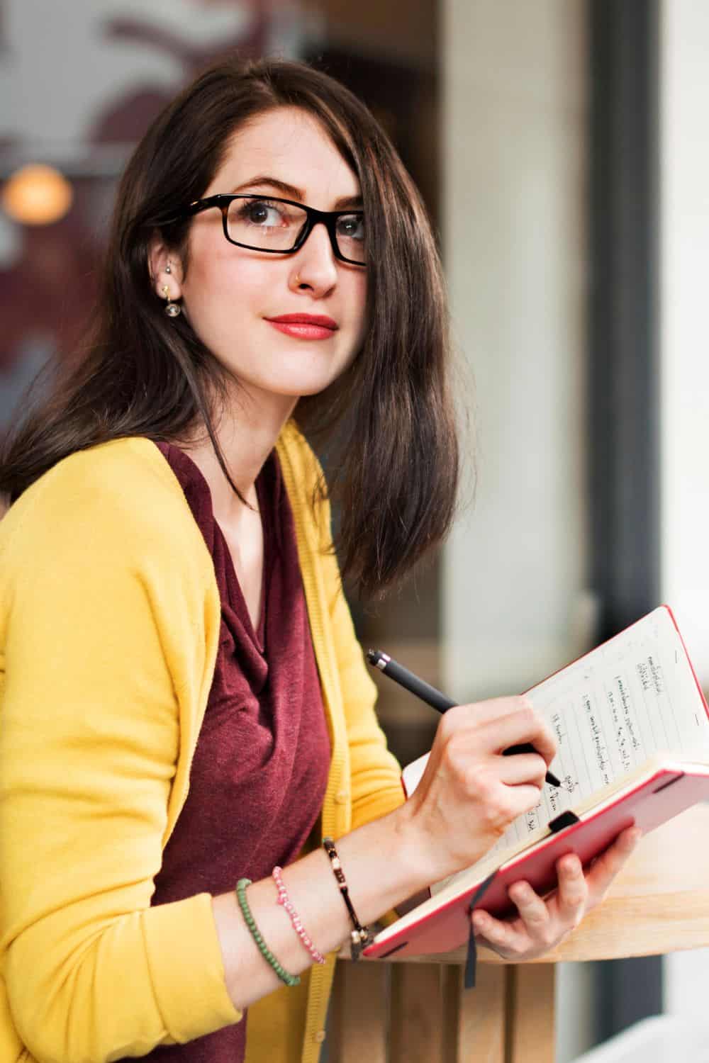 woman writing new years resolutions in a journal