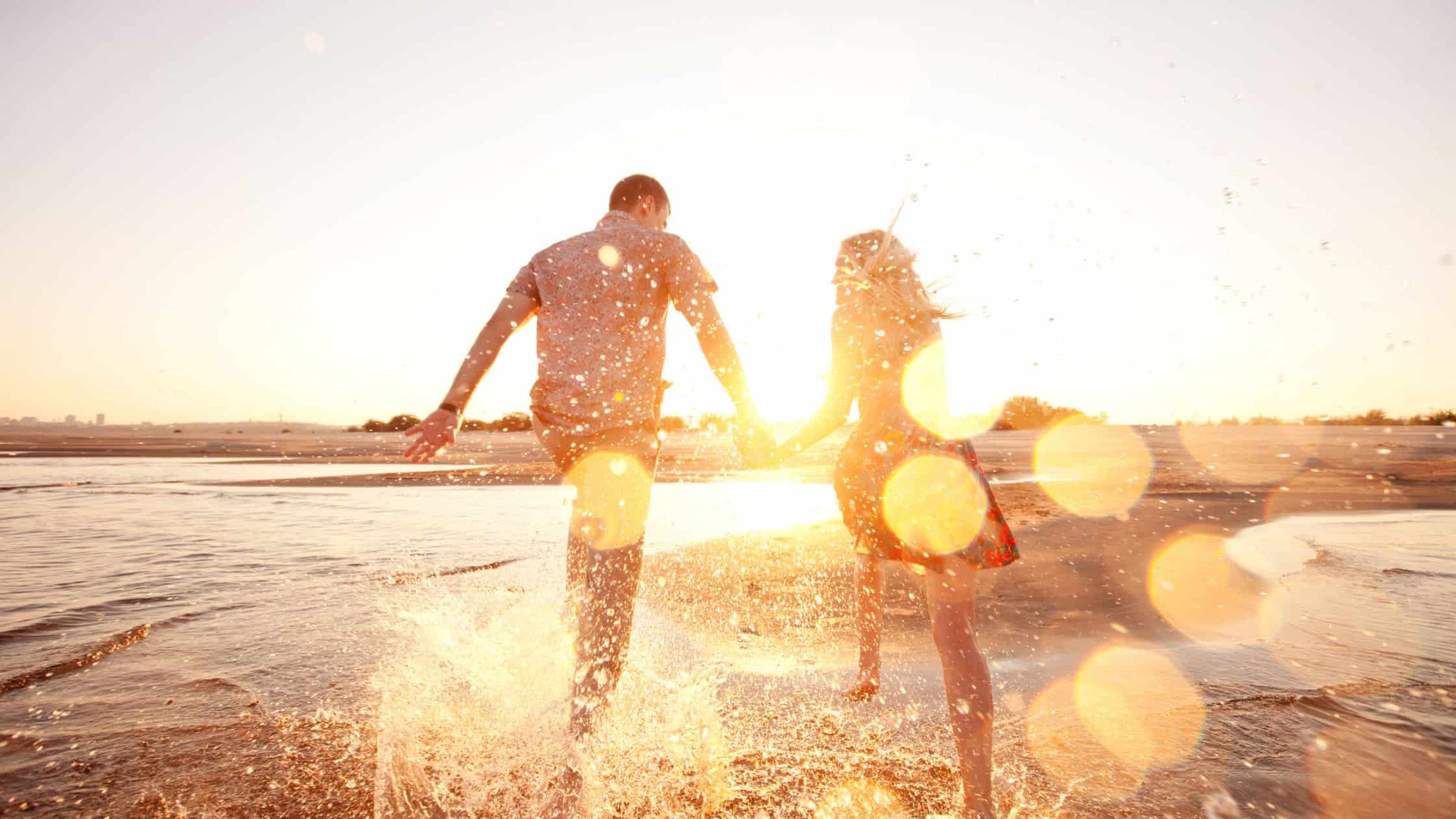 happy couple running on the beach