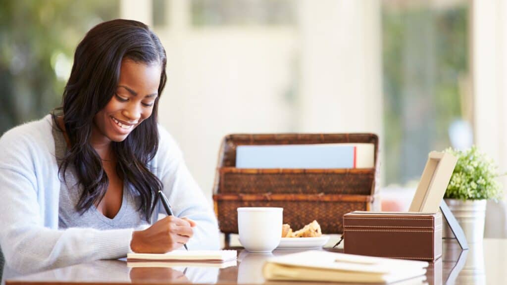 woman reading Bible verses and writing Scripture in the morning