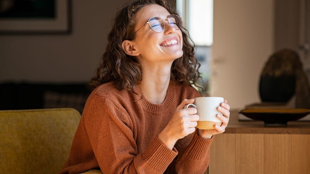 happy, smiling woman drinking coffee in the morning