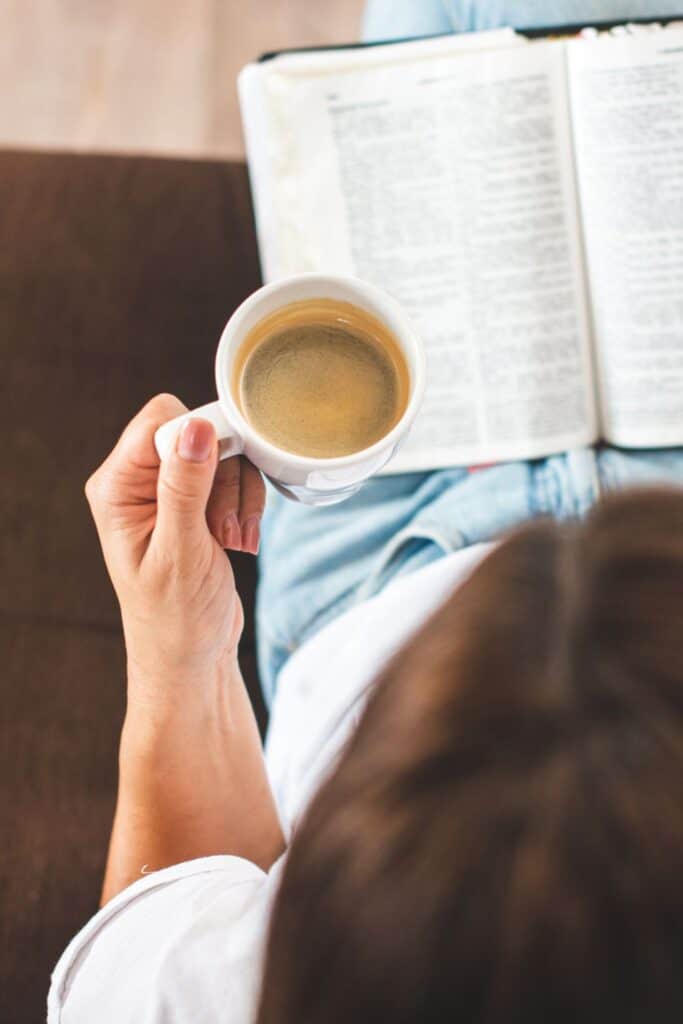 overhead view of a woman reading her Bible with coffee in her hand