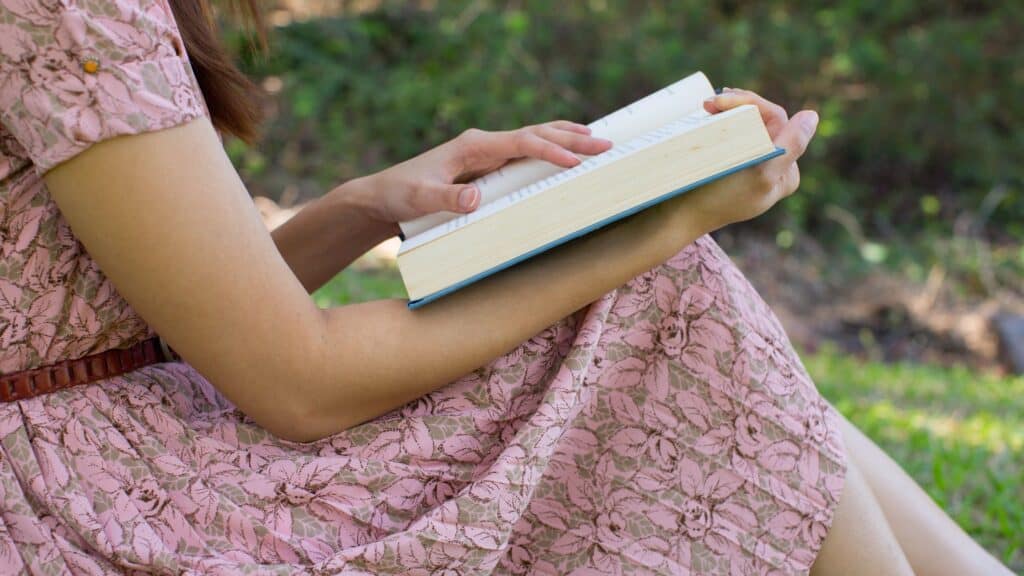 woman in pink dress reading the Bible
