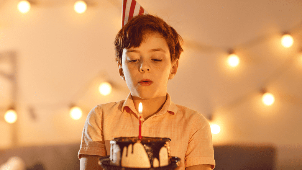 young boy blowing out a birthday candle