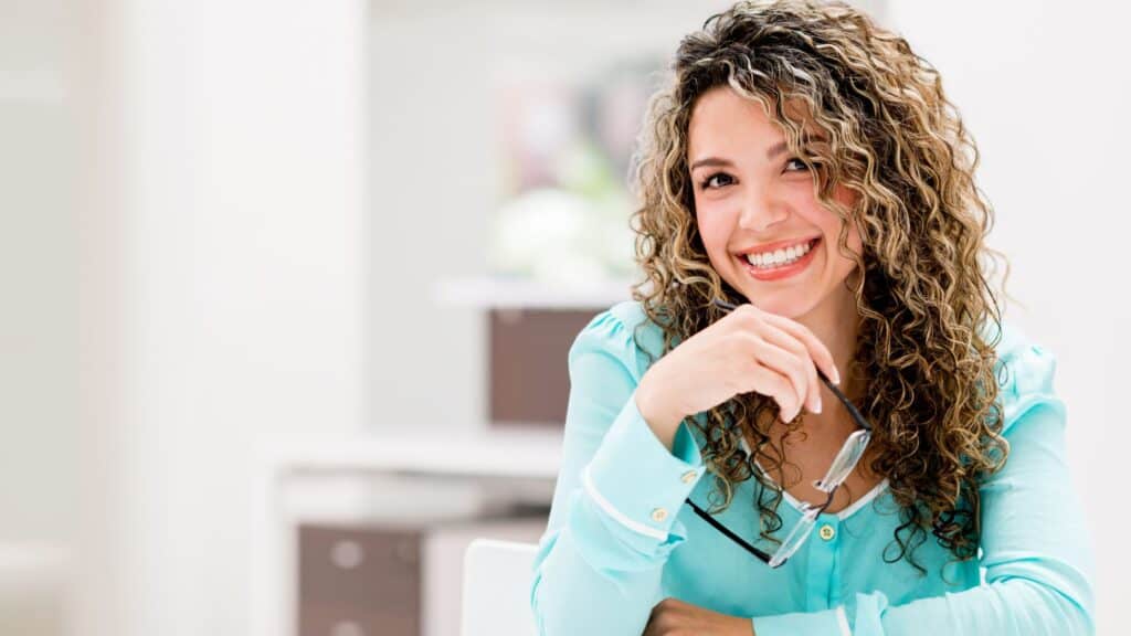 smiling woman sitting at a table in the morning