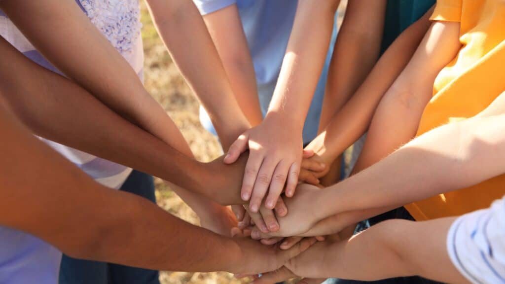 kids hands touching in the center of a circle