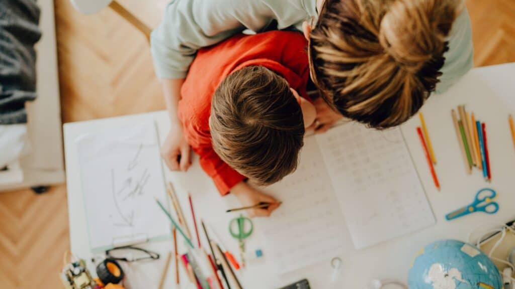 overhead view of a women and child working on homeschool