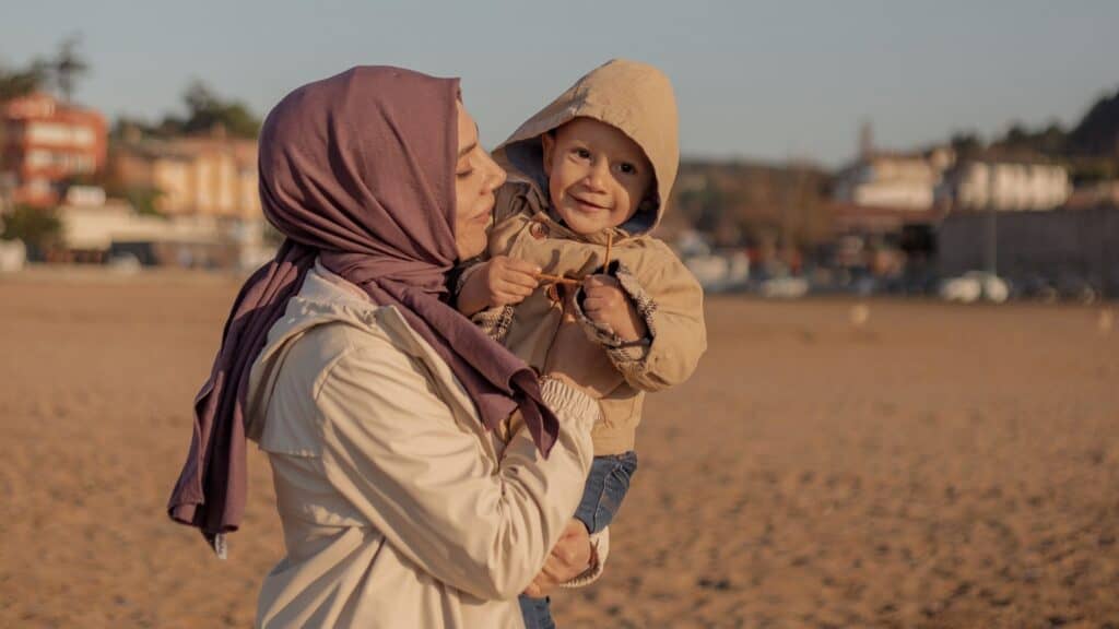 woman wearing a headscarf and holding a young boy
