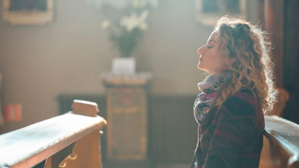 woman sitting in an empty church praying