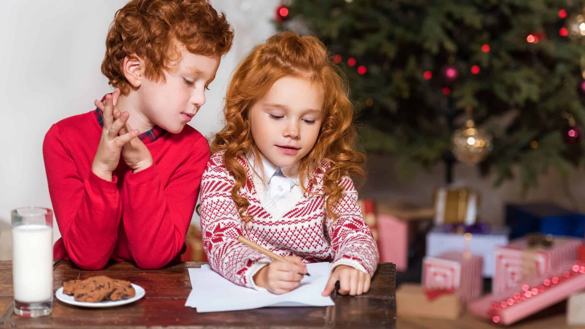 two kids writing Christmas cards