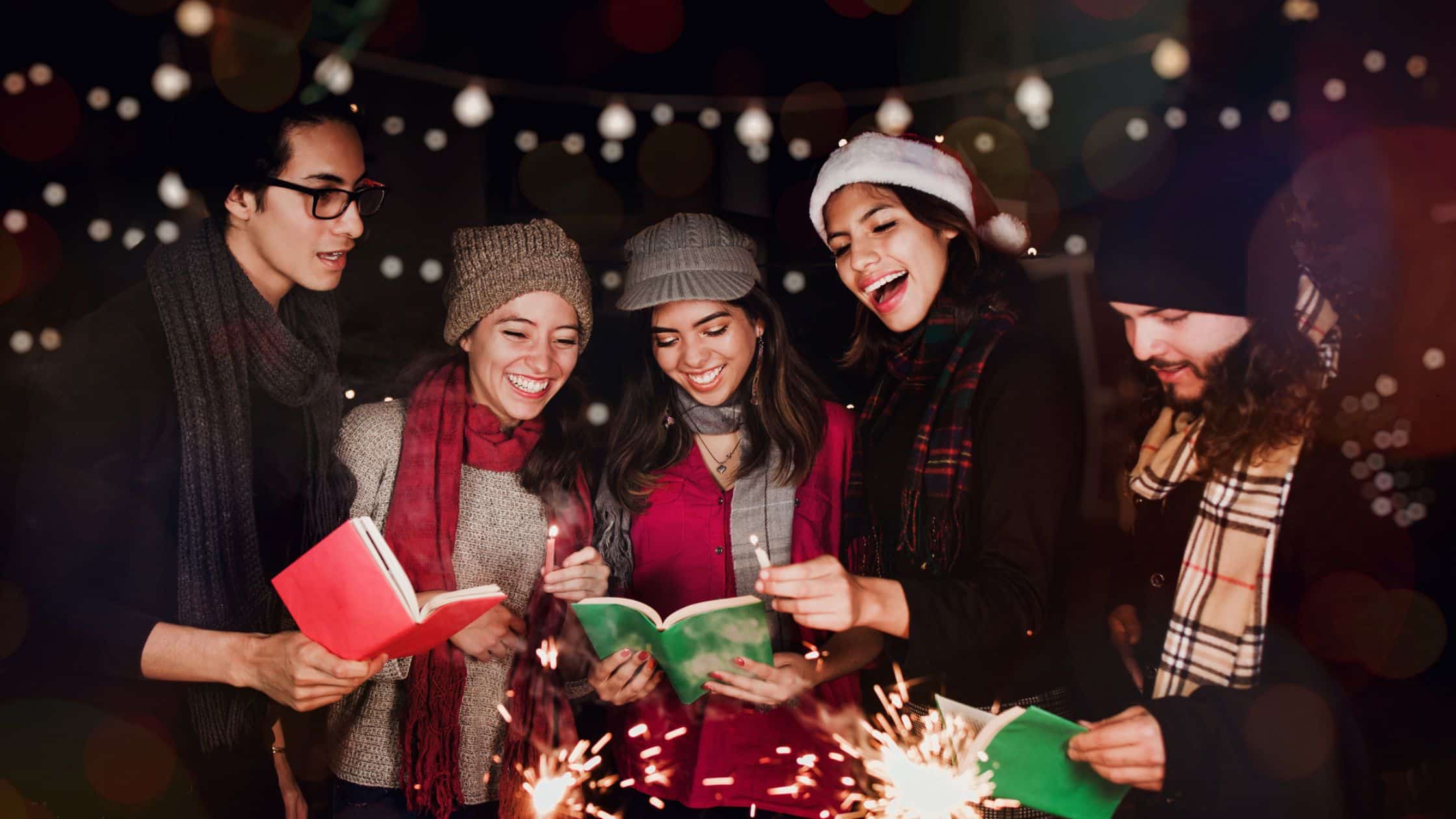 group of people singing Christmas carols by candlelight