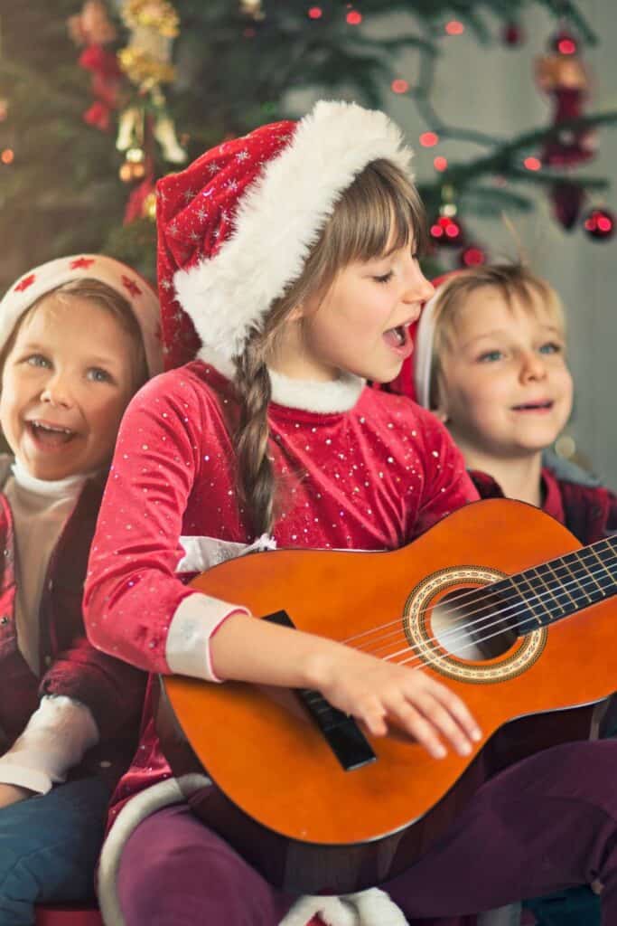 kids playing a guitar and singing at Christmas