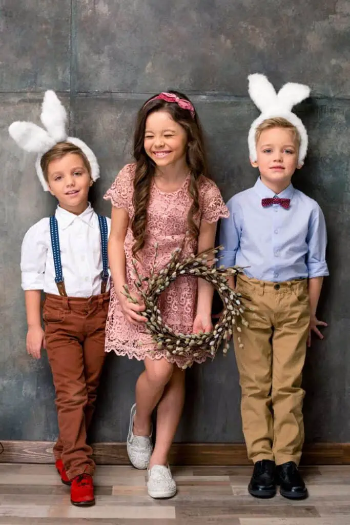 three smiling children with bunny ears