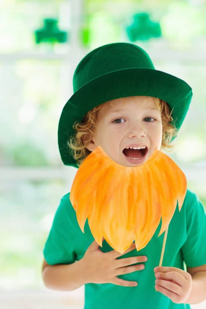 little boy wearing a green hat and orange beard for St. patrick's day