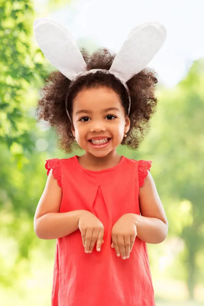 cute little girl wearing an orange dress and bunny ears