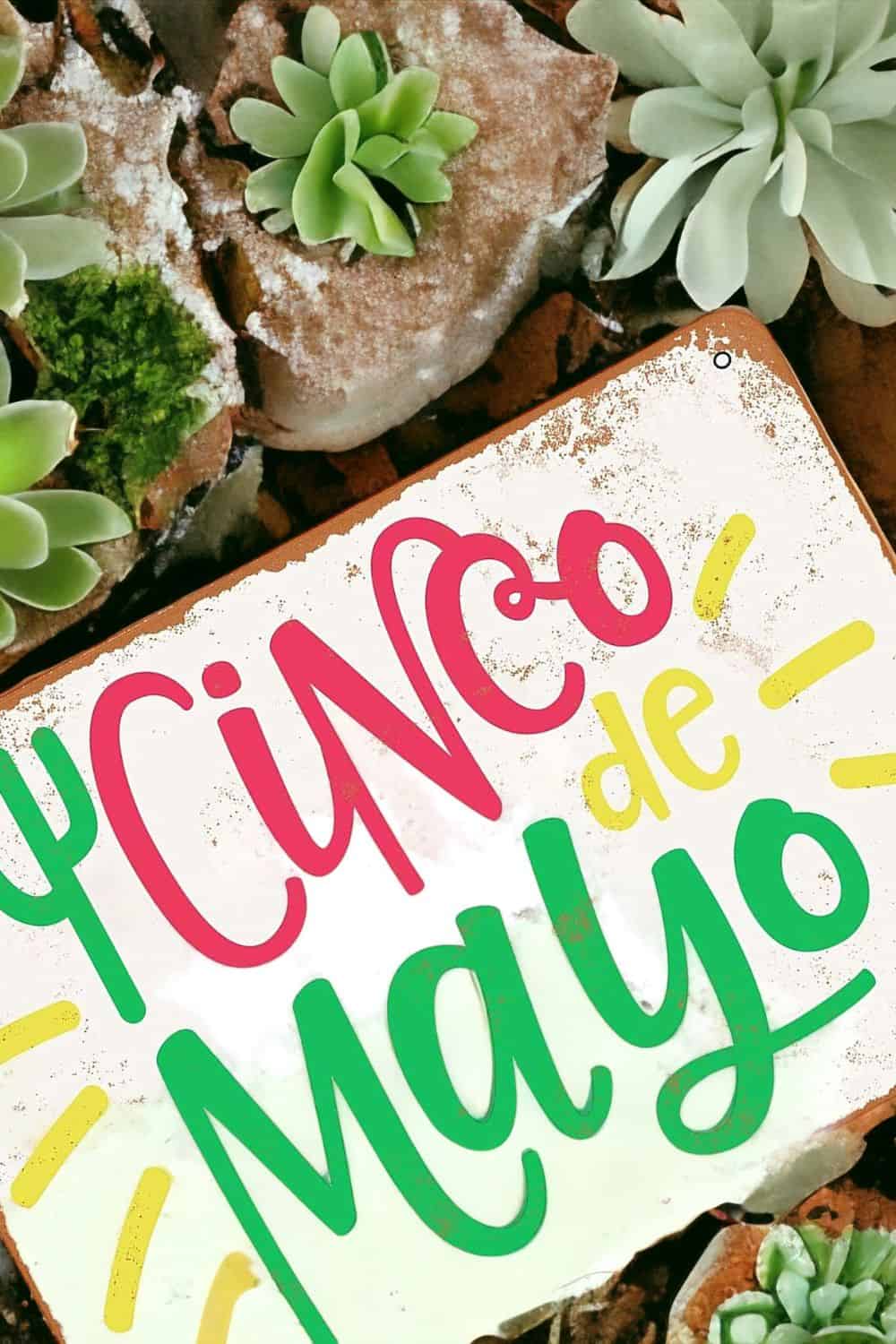 sign that reads "cinco de mayo" on a background of cacti