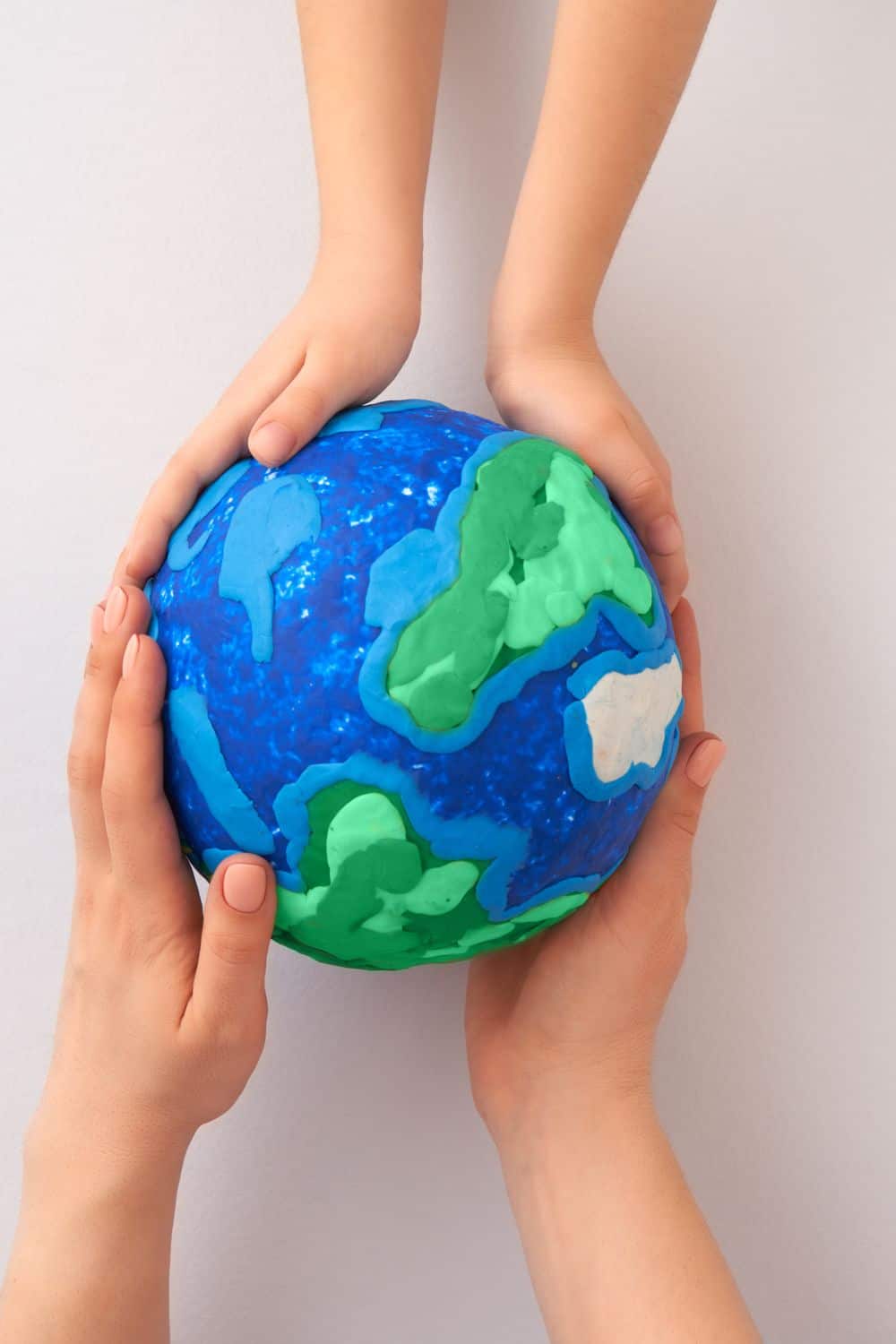 hands holding a model of the earth