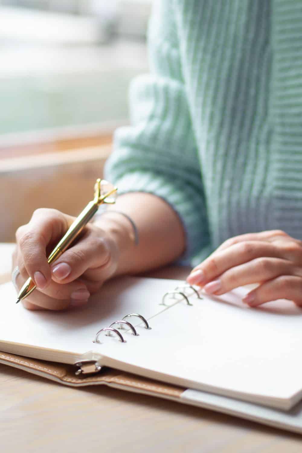 woman writing a family meal plan in a notebook