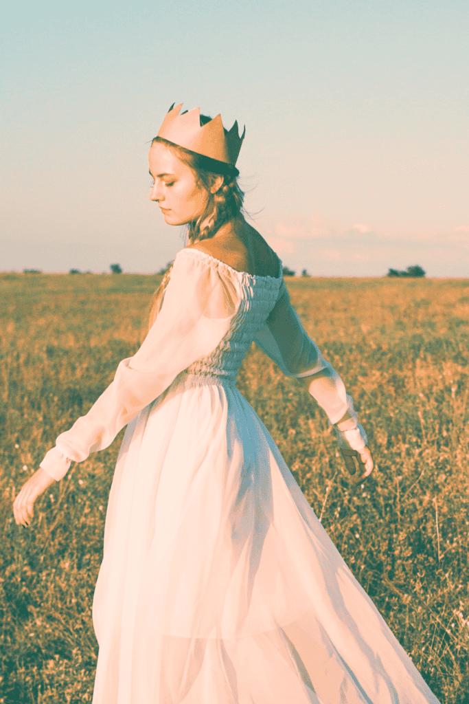 beautiful woman wearing a crown spinning in a field