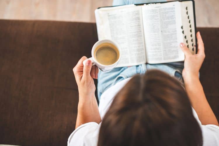 woman reading the bible and drinking coffee