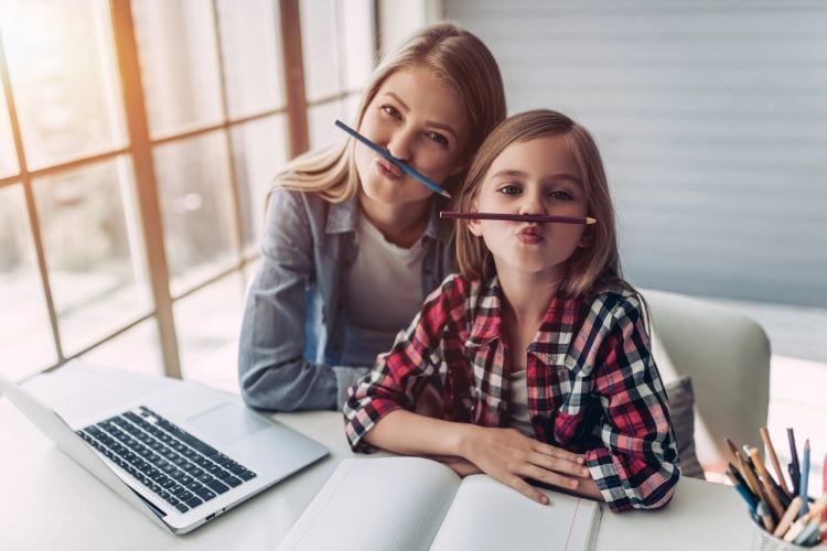 mom and daughter acting silly with pencils on their faces