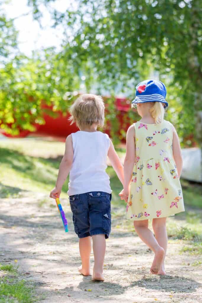 young kids walking down a dirt road 