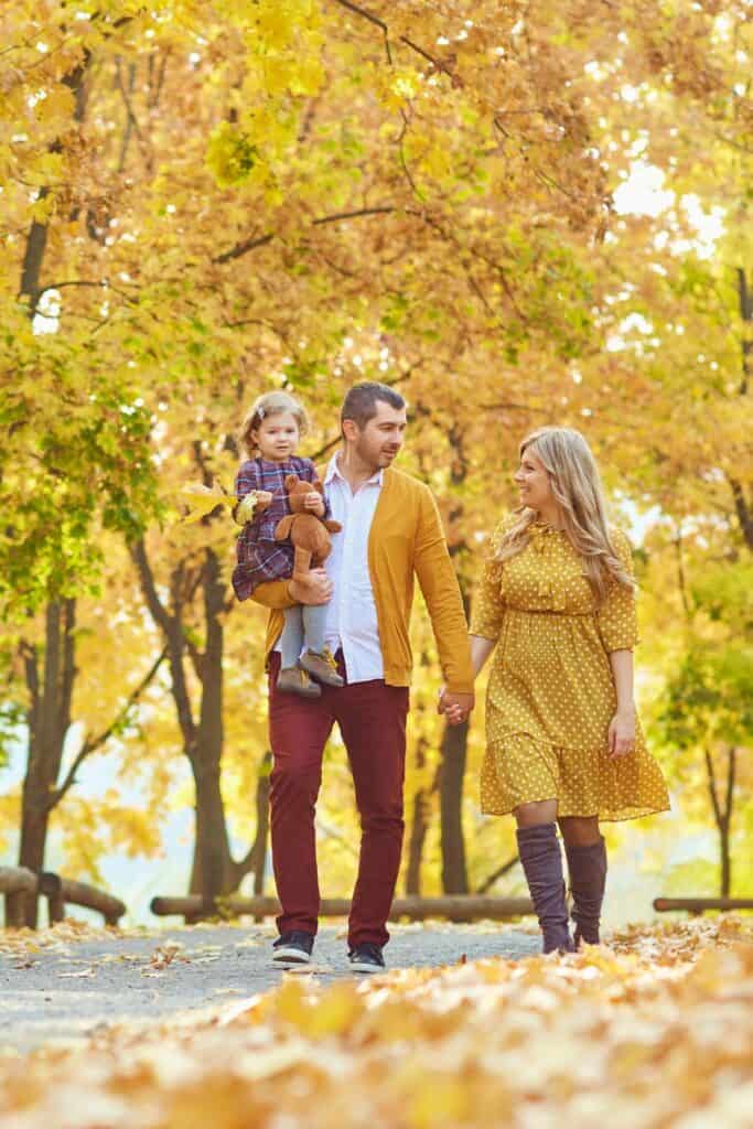 family walking through trees in the fall 