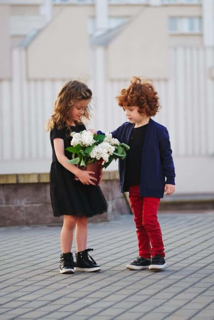 little boy giving a bouquet of flowers to a little girl