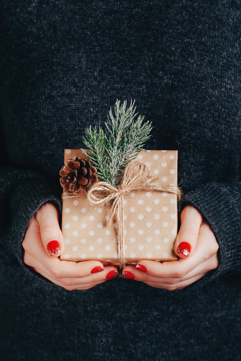 woman's hands holding a wrapped gift