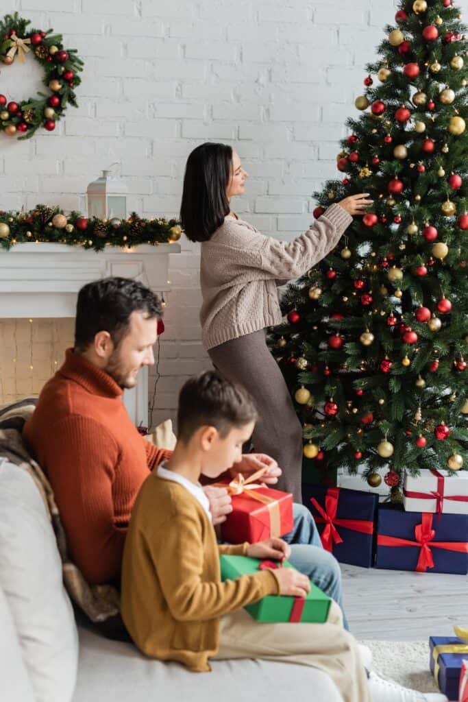 happy family decorating a Christmas tree and wrapping gifts