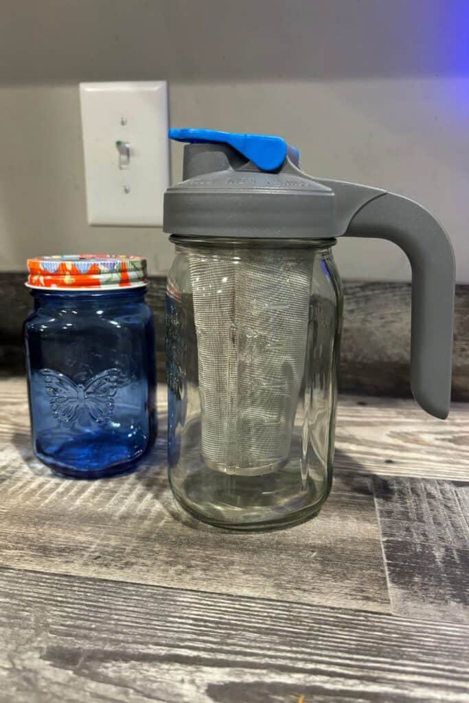 cold brew coffee maker and a blue mason jar sitting on a kitchen counter