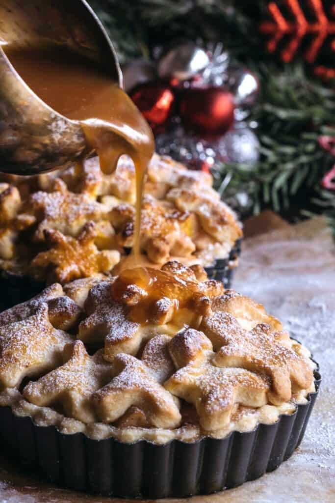 apple pie with caramel sauce being poured on top