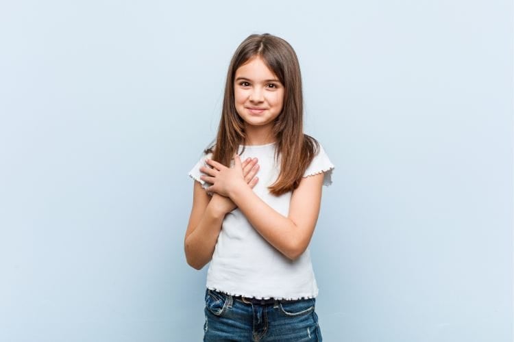 girl with her hands clasped over her heart in gratitude