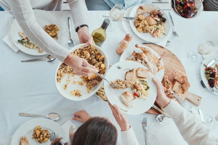 hands passing around food at a table