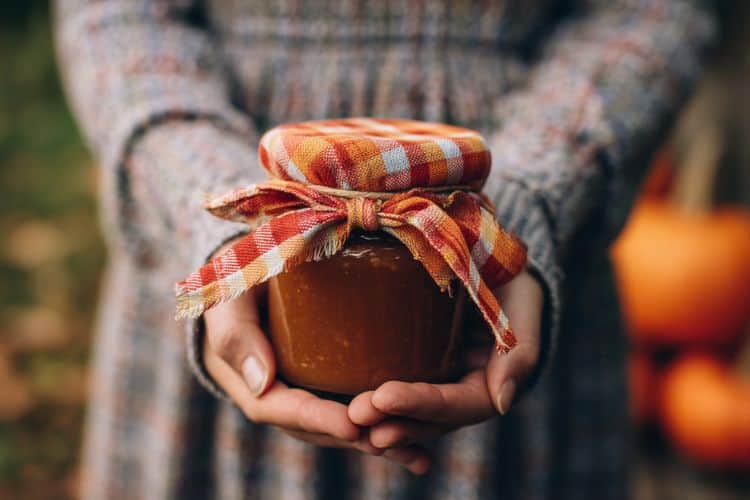hands holding a jar of apple butter as a gift